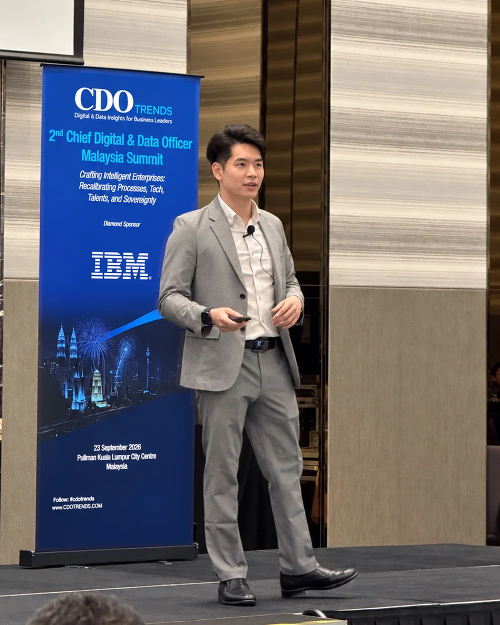 Joshua Yeoh delivering the keynote beside the Chief Digital & Data Officer Malaysia Summit II banner